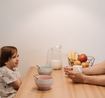 A father having a warm conversation with his children during breakfast at home.